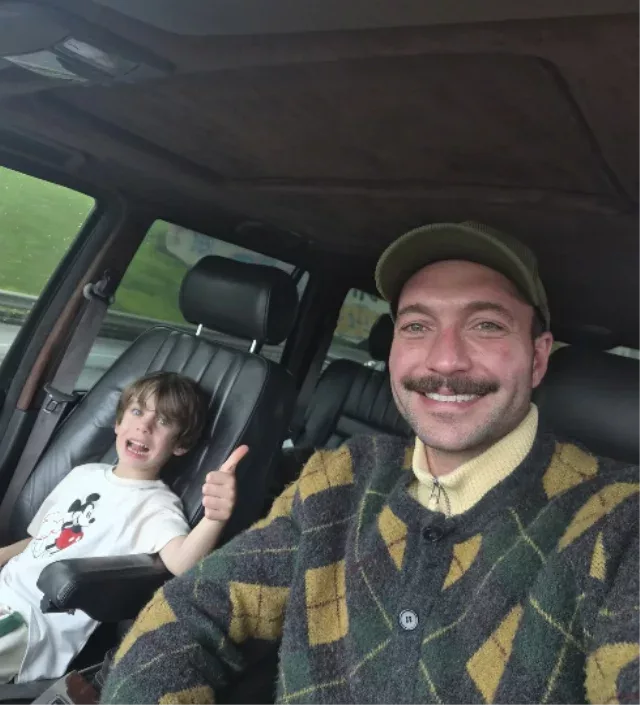 Gorkem Sevindik and his son posing in a car